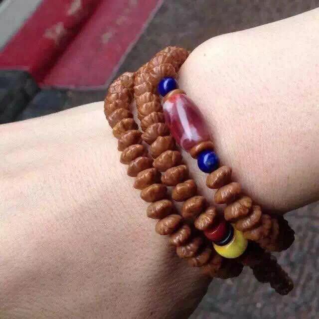 这好像叫金钱菩提子店主说红的血珀白的象牙不知真假这个菩提子什么