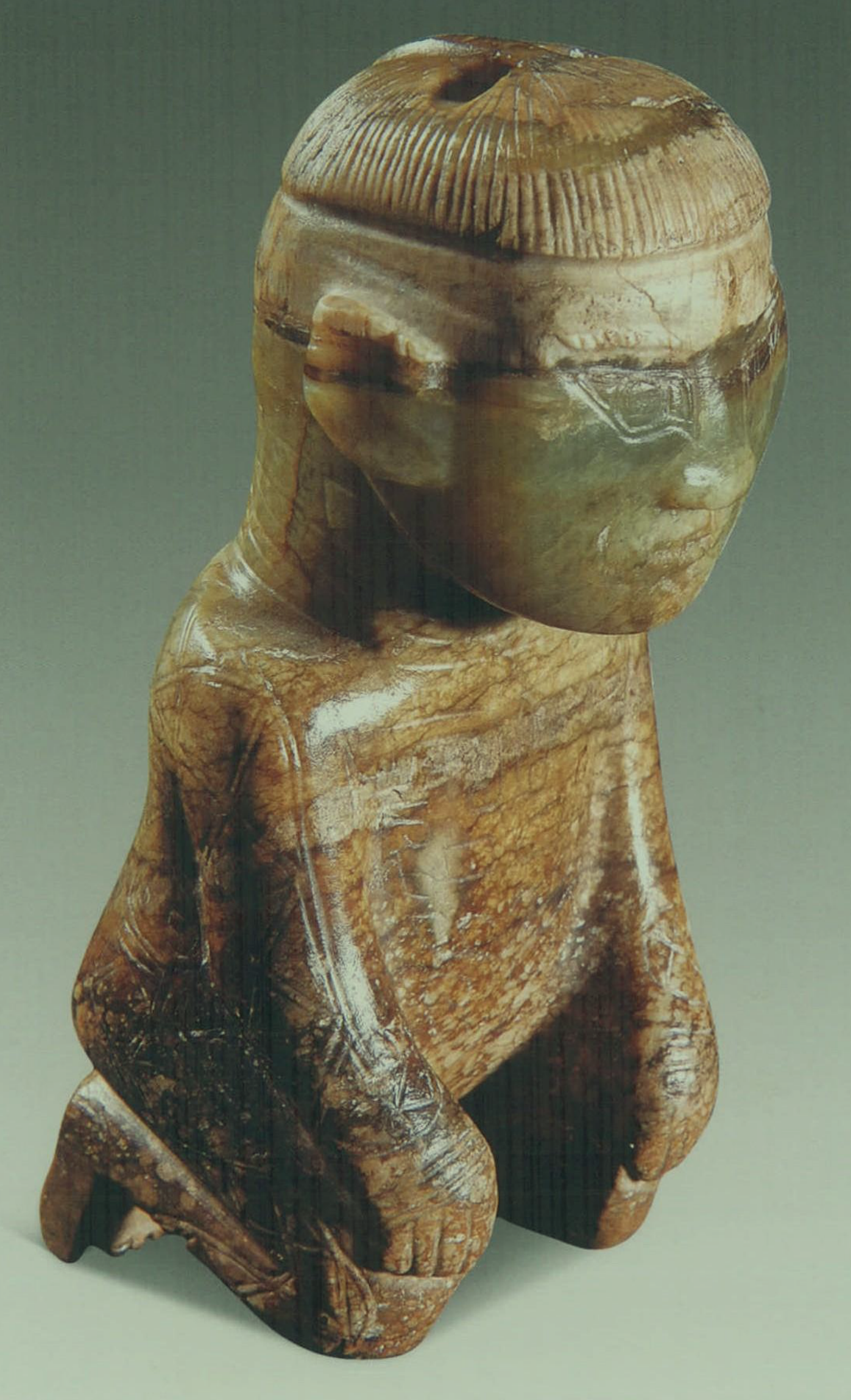 妇好墓出土的商代圆雕跽坐玉人背后的发条状物是做什么用的